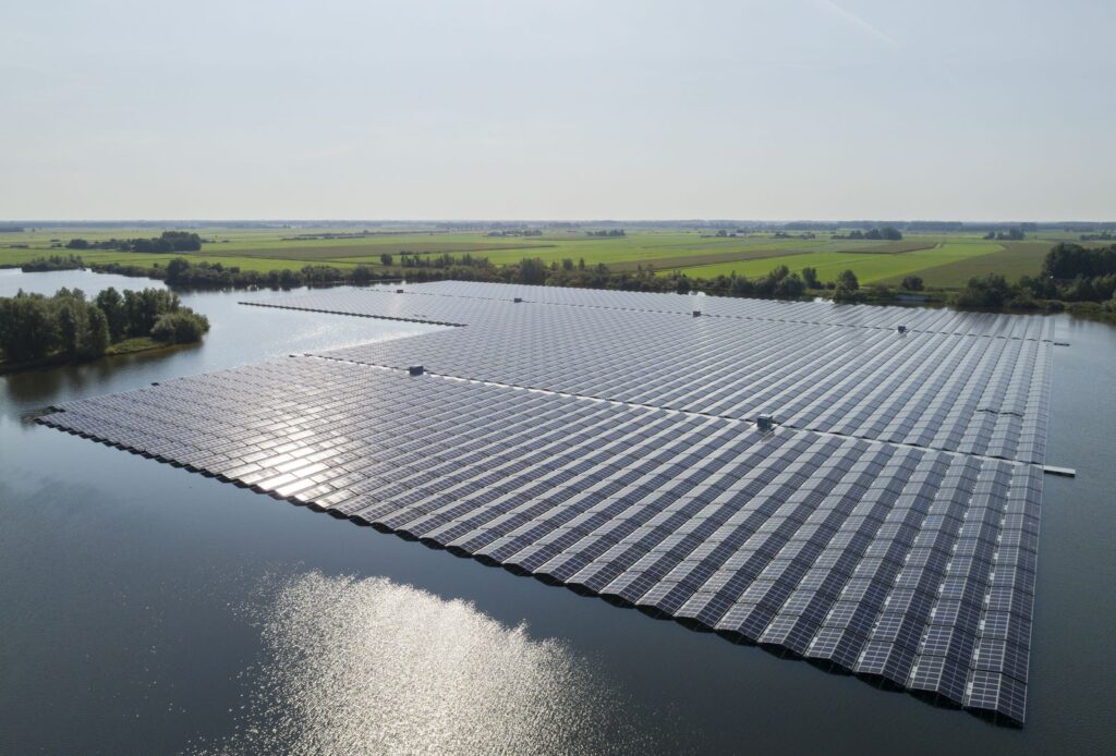 Aerial view of a floating solar farm on a lake surrounded by farmland in the Netherlands